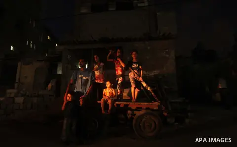 Palestinians sit on a cart a street during power outage in Gaza city on July 27, 2015. Independent Commission for Human Rights warned Saturday of the aggravated humanitarian situation in Gaza due to continued electricity...