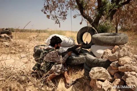 A fighter from the Free Syrian Army takes position following clashes with the pro-regime forces, in Aziza village in the northern Syrian city of Aleppo, on July 28, 2015. Photo by Ameer al-Halbi