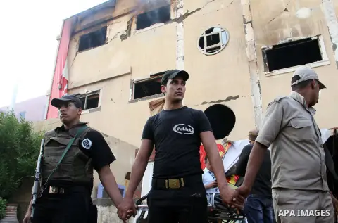 Egyptian police and ambulances are seen outside the Al-Helw furniture factory north of the capital Cairo after the building caught on fire killing at least 19 working according to security and health workers, on July 28,...