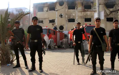 Egyptian police and ambulances are seen outside the Al-Helw furniture factory north of the capital Cairo after the building caught on fire killing at least 19 working according to security and health workers, on July 28,...