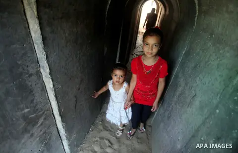 Palestinian girls walk in a military tunnel during a weapons exhibition in a military-style camp organized by the Hamas movement in Gaza City on July 28, 2015. Hamas's armed wing organized "Liberation Youths Camps" for y...