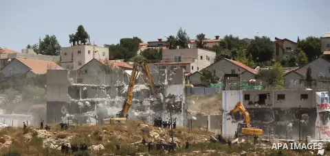 Israeli heavy machinery demolish vacant apartment blocs by order of Israel's high court, in the West Bank Jewish settlement of Beit El near Ramallah July 29, 2015. Israel gave final approval on Wednesday for plans to bui...