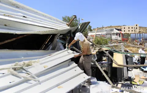 Palestinians search for their belongings after their businesses, consisting of a wedding hall and shop, were razed by the Israeli military in the Arab east Jerusalem neighbourhood of Beit Hanina on July 29, 2015. Accordi...
