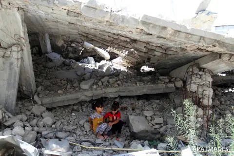 Palestinian girls play on the rubble of a house, which was destroyed during the 50-day war between Israel and Hamas militants in the summer of 2014, in Rafah in the southern Gaza Strip on July 29, 2015. An analysis of an...