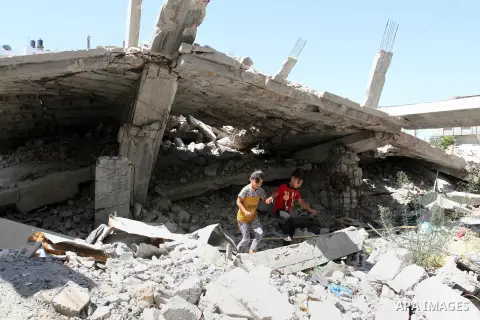 Palestinian girls play on the rubble of a house, which was destroyed during the 50-day war between Israel and Hamas militants in the summer of 2014, in Rafah in the southern Gaza Strip on July 29, 2015. An analysis of an...