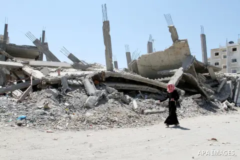 A Palestinian woman walks past the rubble of a house, which was destroyed during the 50-day war between Israel and Hamas militants in the summer of 2014, in Rafah in the southern Gaza Strip on July 29, 2015. An analysis...