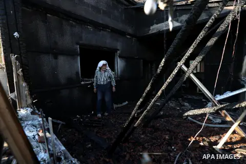 A Palestinian man inspects a house that was badly damaged from a suspected attack by Jewish extremists on two houses at Kafr Duma village near the West Bank city of Nablus July 31, 2015. The house had been empty and ther...
