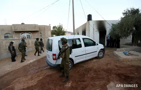 Israeli soldiers inspect a Palestinian house that was badly damaged from a suspected attack by Jewish extremists on two houses at Kafr Duma village near the West Bank city of Nablus July 31, 2015. The house had been empt...