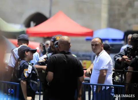 Israeli police officers chek the IDs of Muslim Palestinians as others take part in Friday noon prayers in the east Jerusalem neighbourhood of Ras al-Amud on July 31, 2015, following restrictions by Israeli police to allo...