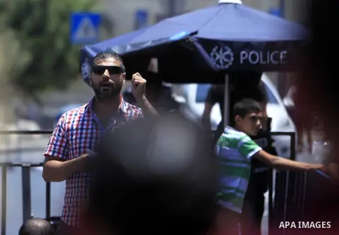 Israeli security forces stand guard as Muslim Palestinians take part in Friday noon prayers in the east Jerusalem neighbourhood of Ras al-Amud on July 31, 2015, following restrictions by Israeli police to allow entry to...
