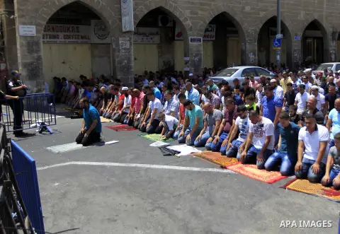 Israeli security forces stand guard as Muslim Palestinians take part in Friday noon prayers in the east Jerusalem neighbourhood of Ras al-Amud on July 31, 2015, following restrictions by Israeli police to allow entry to...