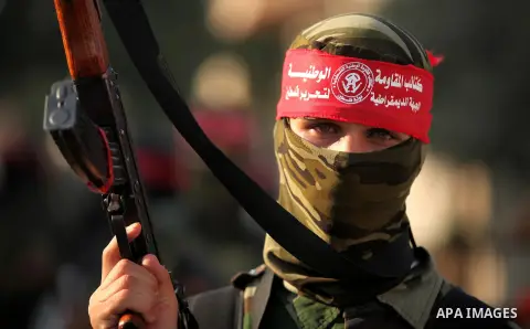 A masked Palestinian militant of the National Resistance Brigades, a group linked to the Democratic Front for the Liberation of Palestine holds his weapon during a military parade against the killing of a 18-month-old Pa...