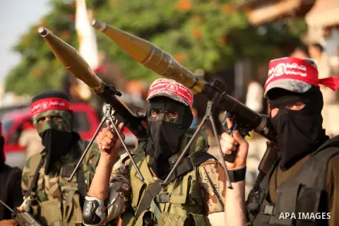 Masked Palestinian militants of the National Resistance Brigades, a group linked to the Democratic Front for the Liberation of Palestine hold their weapons during a military parade against the killing of a 18-month-old P...