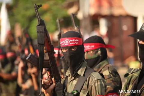 Masked Palestinian militants of the National Resistance Brigades, a group linked to the Democratic Front for the Liberation of Palestine hold their weapons during a military parade against the killing of a 18-month-old P...