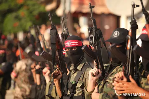 Masked Palestinian militants of the National Resistance Brigades, a group linked to the Democratic Front for the Liberation of Palestine hold their weapons during a military parade against the killing of a 18-month-old P...