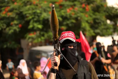 Masked Palestinian militants of the National Resistance Brigades, a group linked to the Democratic Front for the Liberation of Palestine hold their weapons during a military parade against the killing of a 18-month-old P...