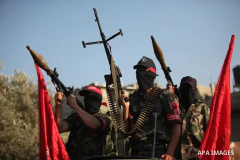 Masked Palestinian militants of the National Resistance Brigades, a group linked to the Democratic Front for the Liberation of Palestine hold their weapons during a military parade against the killing of a 18-month-old P...