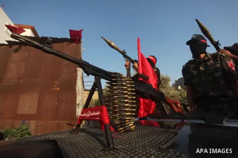 Masked Palestinian militants of the National Resistance Brigades, a group linked to the Democratic Front for the Liberation of Palestine hold their weapons during a military parade against the killing of a 18-month-old P...