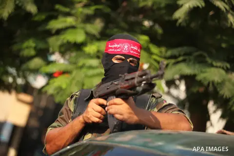 A masked Palestinian militant of the National Resistance Brigades, a group linked to the Democratic Front for the Liberation of Palestine holds his weapon during a military parade against the killing of a 18-month-old Pa...