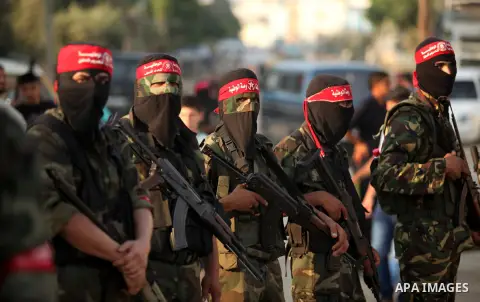 Masked Palestinian militants of the National Resistance Brigades, a group linked to the Democratic Front for the Liberation of Palestine hold their weapons during a military parade against the killing of a 18-month-old P...
