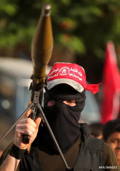 A masked Palestinian militant of the National Resistance Brigades, a group linked to the Democratic Front for the Liberation of Palestine holds his weapon during a military parade against the killing of a 18-month-old Pa...