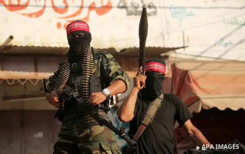 Masked Palestinian militants of the National Resistance Brigades, a group linked to the Democratic Front for the Liberation of Palestine hold their weapons during a military parade against the killing of a 18-month-old P...