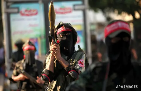 Masked Palestinian militants of the National Resistance Brigades, a group linked to the Democratic Front for the Liberation of Palestine hold their weapons during a military parade against the killing of a 18-month-old P...