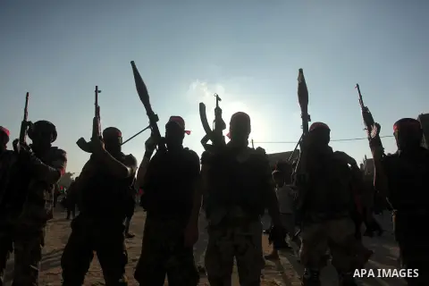 Masked Palestinian militants of the National Resistance Brigades, a group linked to the Democratic Front for the Liberation of Palestine hold their weapons during a military parade against the killing of a 18-month-old P...