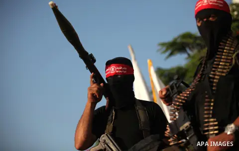 Masked Palestinian militants of the National Resistance Brigades, a group linked to the Democratic Front for the Liberation of Palestine hold their weapons during a military parade against the killing of a 18-month-old P...