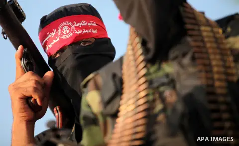 Masked Palestinian militants of the National Resistance Brigades, a group linked to the Democratic Front for the Liberation of Palestine hold their weapons during a military parade against the killing of a 18-month-old P...