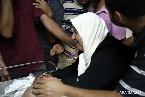 The mother of Mohammed al-Masri, 17, mourns over his body at a hospital morgue, in Beit Lahia in the northern Gaza Strip on July 31, 2015. Al-Masri killed and another wounded after being shot by Israeli gunfire in the no...