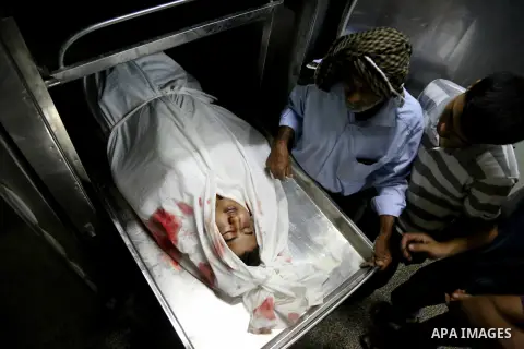 A Palestinian relative mourns over ther body of Mohammed al-Masri, 17, at a hospital morgue, in Beit Lahia in the northern Gaza Strip on July 31, 2015. Al-Masri killed and another wounded after being shot by Israeli gunf...