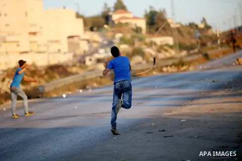 Palestinian protesters use slingshots during clashes with Israeli security forces earby the Jalazoun refugee camp and the Jewish settlement of Beit El, north of Ramallah, after a demonstration in reaction to the death of...