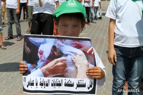 Palestinian children carry a funeral stretcher with a picture of 18-month-old Ali Saad Dawabsha, the toddler who was burned to death by suspected Jewish extremists, on August 1, 2015 in Khan Yunis in the southern Gaza St...