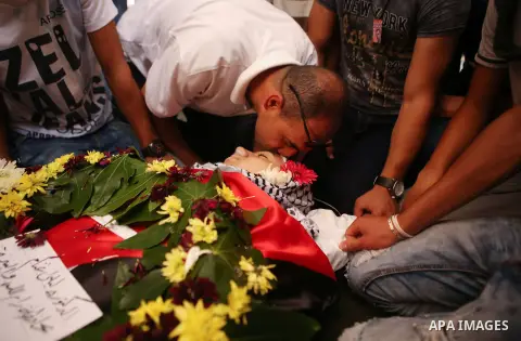 Mourners gather around the body of Palestinian youth Laith al-Khaldi during his funeral near the West Bank city of Ramallah August 1, 2015. Al-Khaldi died on Saturday at a West Bank hospital following a clash with Israel...