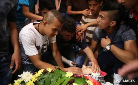 Mourners gather around the body of Palestinian youth Laith al-Khaldi during his funeral near the West Bank city of Ramallah August 1, 2015. Al-Khaldi died on Saturday at a West Bank hospital following a clash with Israel...