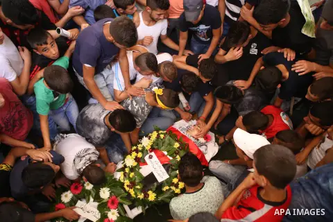 Mourners gather around the body of Palestinian youth Laith al-Khaldi during his funeral near the West Bank city of Ramallah August 1, 2015. Al-Khaldi died on Saturday at a West Bank hospital following a clash with Israel...