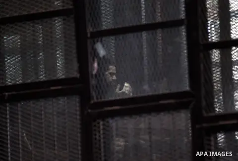 Egyptian radical Islamist Mohammed al-Zawahiri, the brother of Al-Qaeda chief Ayman al-Zawahiri, sits in the defendants cage during his trial with 68 other defendants, at a court in Cairo on August 01, 2015. Photo by Amr...
