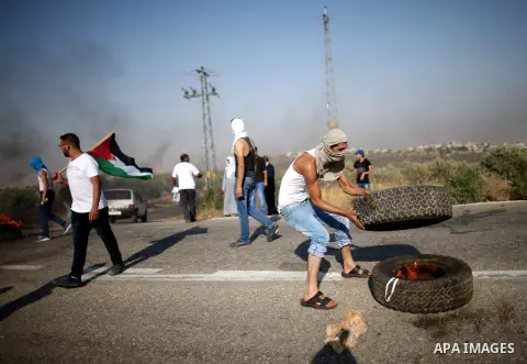 Palestinian burn tires during clashes at the entrance to Duma village near the West Bank city of Nablus, Saturday, Aug. 1, 2015. Tensions remain high after suspected Jewish assailants set fire to a West Bank home and bur...