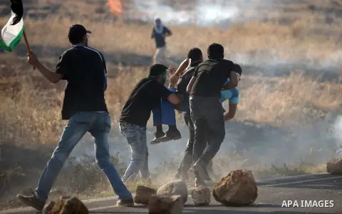 Palestinians protesters carry a wounded man during clashes at the entrance to Duma village near the West Bank city of Nablus, Saturday, Aug. 1, 2015. Tensions remain high after suspected Jewish assailants set fire to a W...