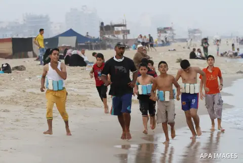Palestinians enjoy the warm weather on a beach along the Mediterranean Sea in Gaza city, on August 2, 2015. Photo by Mohammed Asad