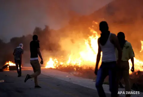 Palestinian protesters burn tires during clashes with Israeli security forces on a street leading to Duma village, on August 2, 2015, following a demonstration in reaction to the death of a Palestinian toddler burnt to d...
