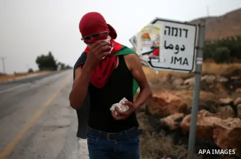 A Palestinian protester prepares to throw stones towards Israeli security forces during clashes on a street leading to Duma village, on August 2, 2015, following a demonstration in reaction to the death of a Palestinian...