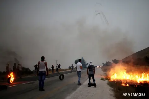 Palestinian protesters throw stones towards Israeli security forces during clashes on a street leading to Duma village, on August 2, 2015, following a demonstration in reaction to the death of a Palestinian toddler burnt...