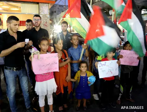 Palestinian children take part in a candle vigil in a protest against the killing of 18-month-old Palestinian Ali Saad Dawabsheh, the toddler who was burned to death by suspected Jewish extremists, in Jabalia in the nort...