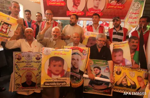 Palestinians take part in a protest demanding release the prisoners in Israeli jails, in front of Red cross office, in Gaza city, on on August 03, 2015. Photo by Ashraf Amra