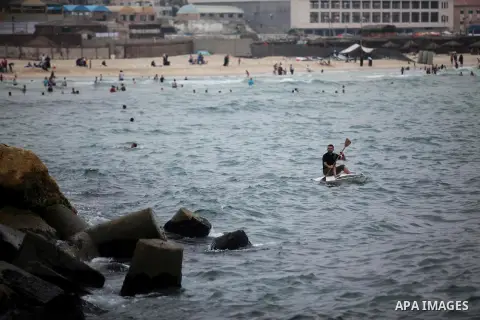 A Palestinian man rides a boat in the Mediterranean Sea on the coast of Gaza City on August 4, 2015. Across the Middle East, temperatures in the high 30’s Centigrade (upper 90’s Fahrenheit) and as high as 50 (122 Fahrenh...