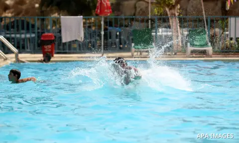 Palestinian youths enjoy swimming in a pool at a park in the West Bank city of Ramallah on August 5, 2015. Across the Middle East, temperatures in the high 30s Centigrade (upper 90s Fahrenheit) and as high as 50 (122 Fah...