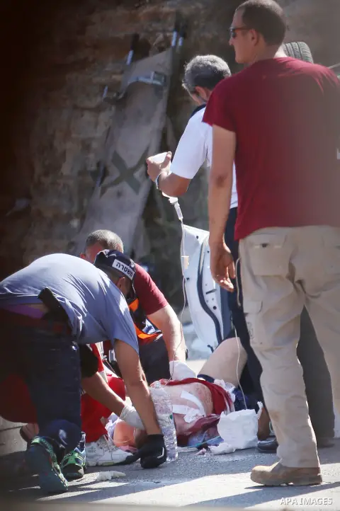 Israeli medics treat a wounded man following rammed in a suspected attack by a Palestinian motorist, near the West Bank city of Ramallah on August 6, 2015. Israeli forces shot and injured a Palestinian man on Thursday af...