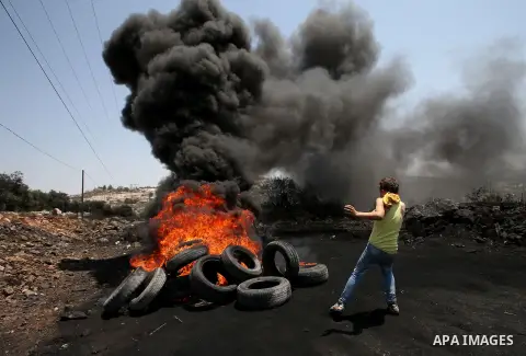 Palestinian protesters burn tires during clashes with Israeli security forces following a protest against the expropriation of Palestinian land by Israel in the West Bank village of Kafr Qaddum, near the northern city of...